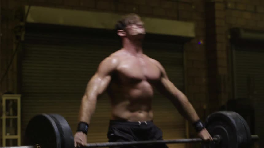 A shirtless man repeatedly deadlifts some weights