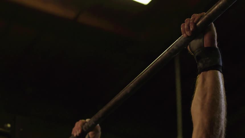 Man uses bar while exercising to pull himself above it