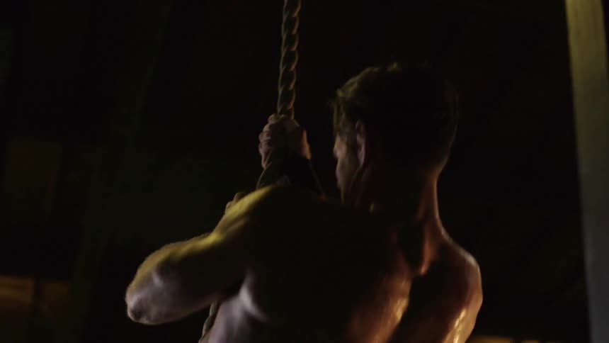 A man jumps on a rope and climbs