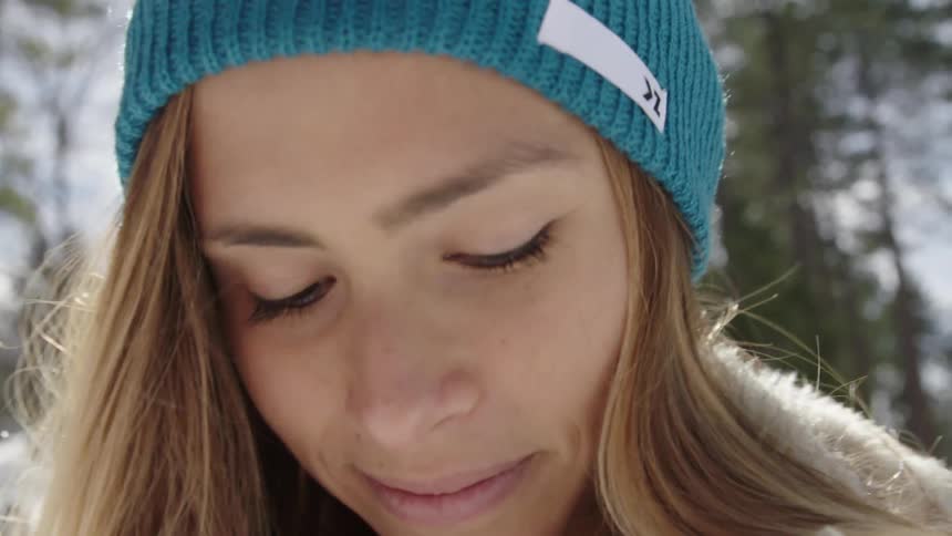 Woman wearing a knitted hat smiling on a cold day