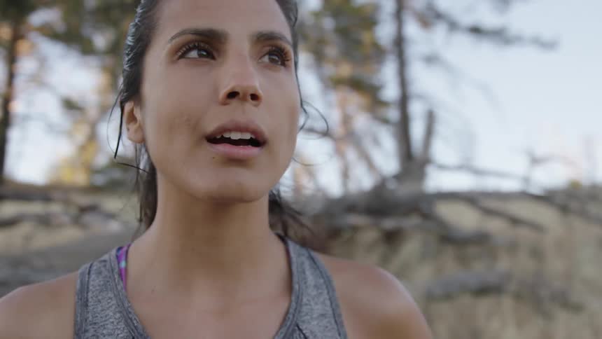 A sweaty woman looking around as she pants