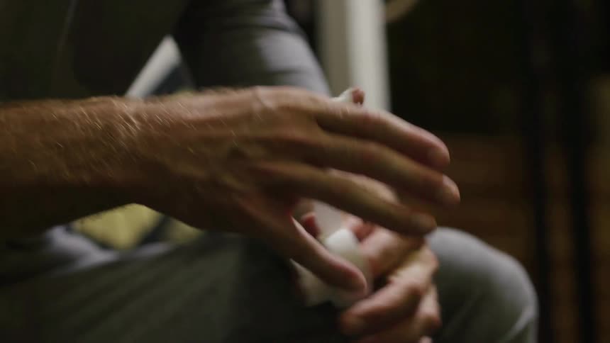 A man winding sports tape around his thumb