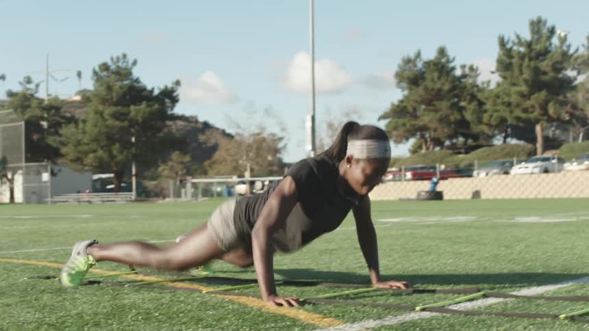 Female athlete exercising at a city field