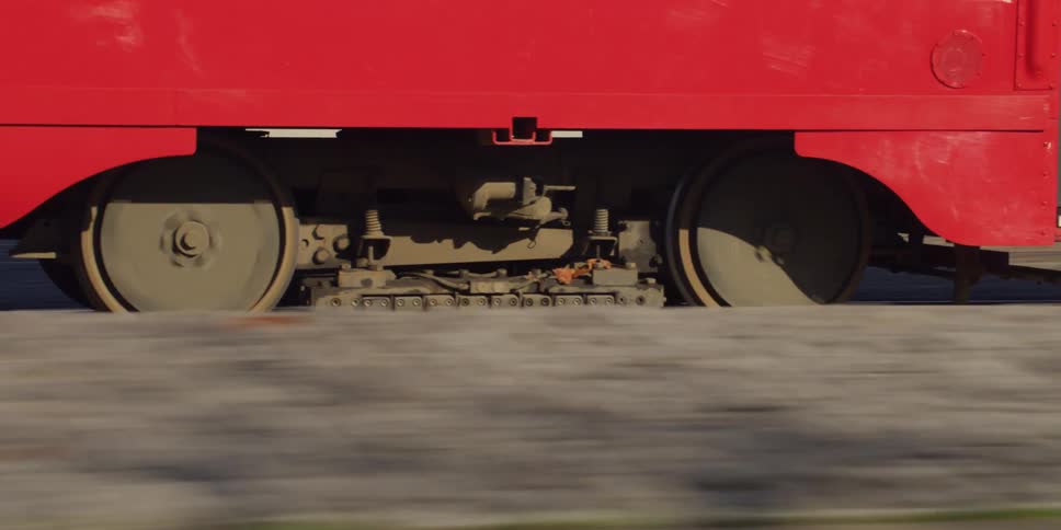 The wheels of a red train as it travels on a track