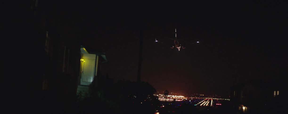 Airplane flying towards runway at night
