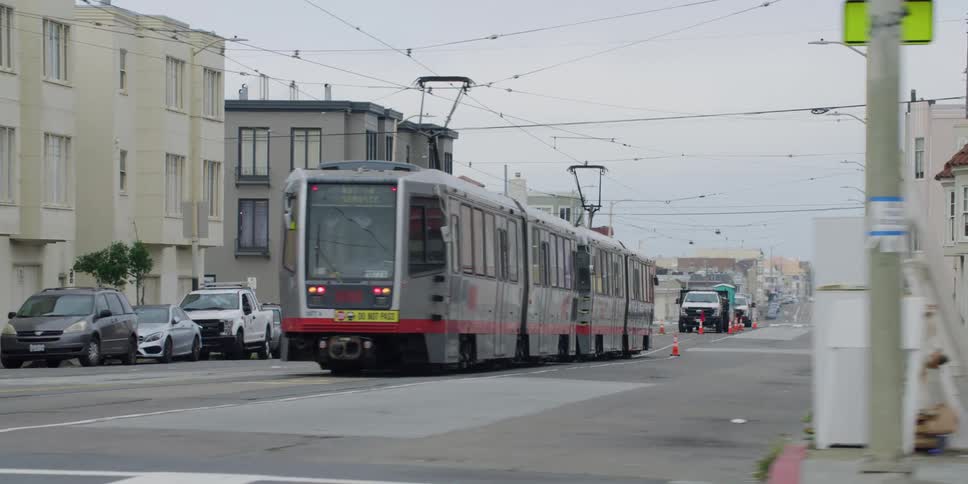 Tram stops on rails along the streets of a town and carries passengers
