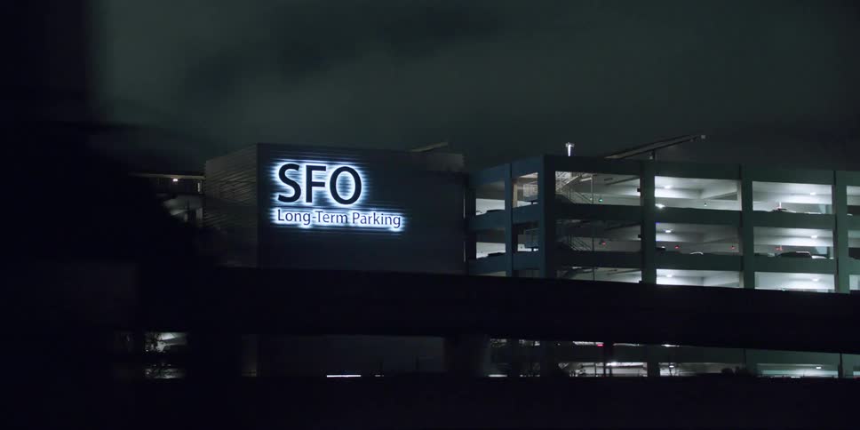 Vehicles drive past the large building
