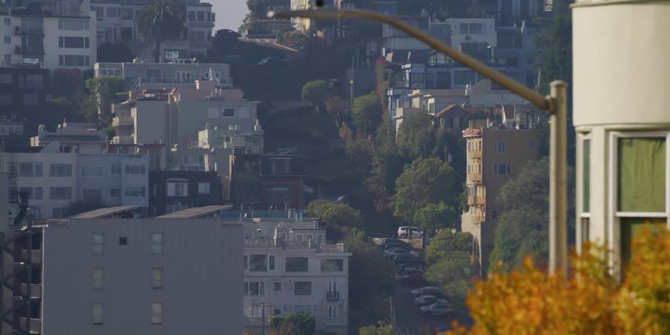 Aerial view of distant hilly street with buildings in city