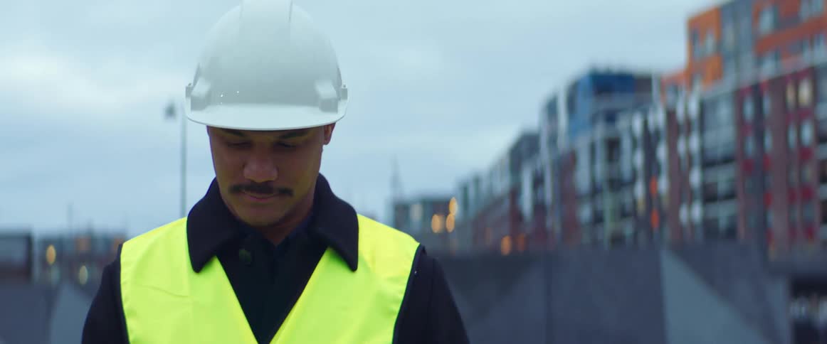 A construction worker holds a clipboard on the site