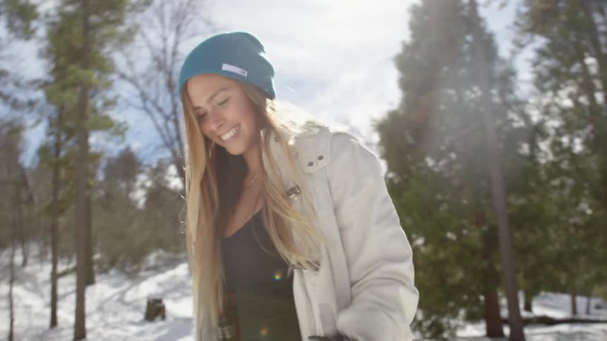 Woman smiling and spinning around in the snow