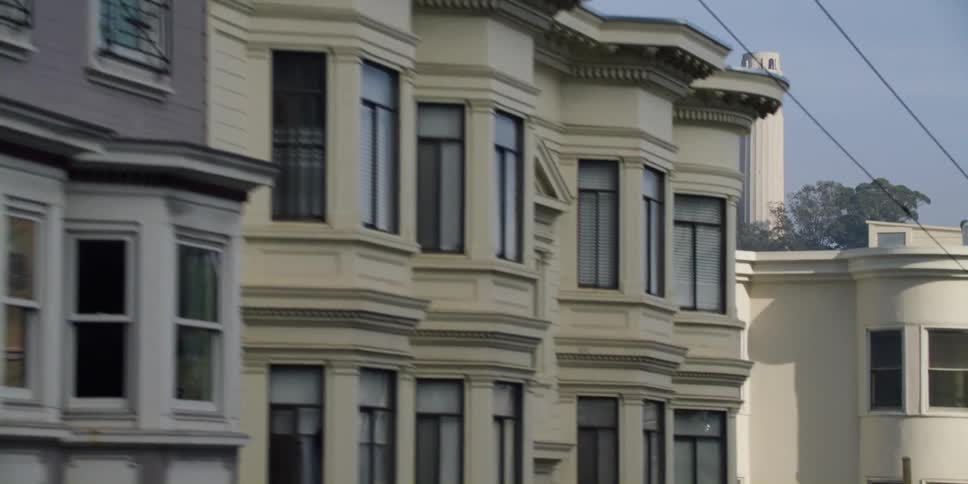 Apartment buildings with tower on hill in the background in the city