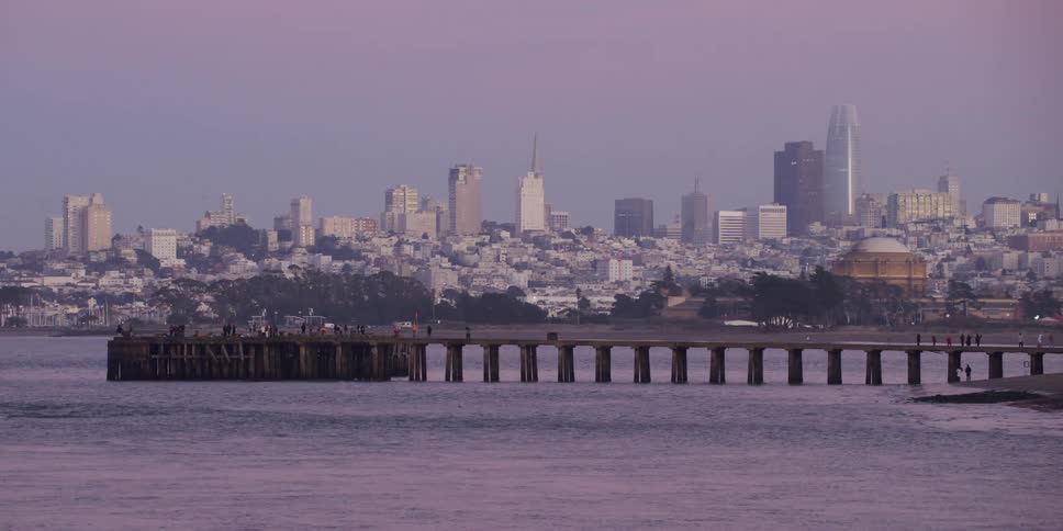 People walk on the pier near the city
