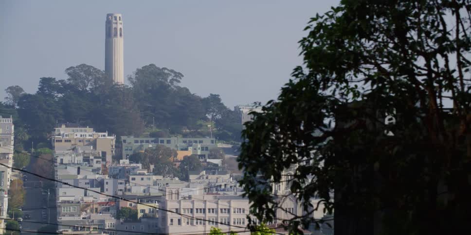 A parked vehicle sits perpendicular across from a neighborhood along a hill
