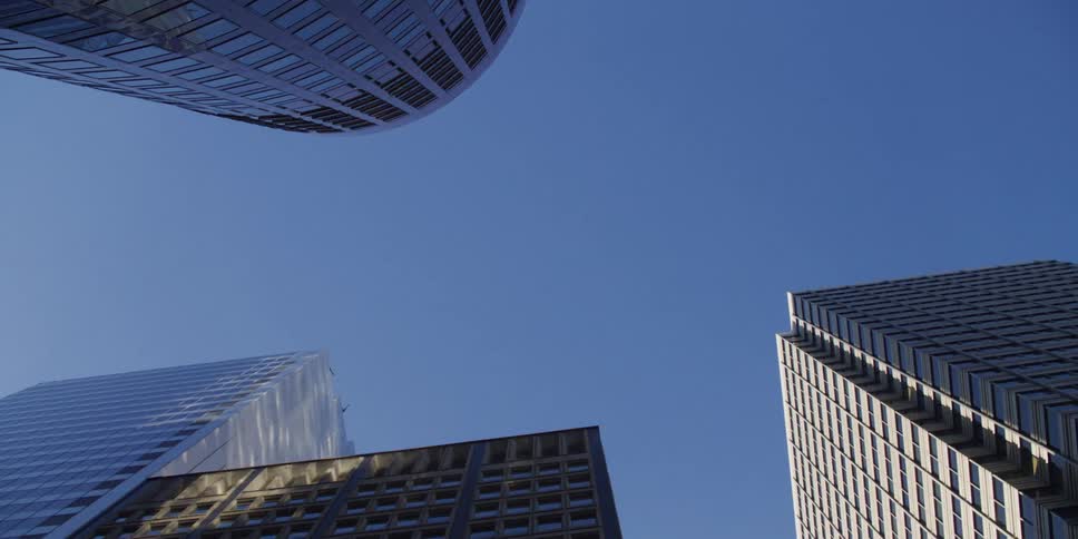 Looking up at tall skyscrapers in a clear blue sky