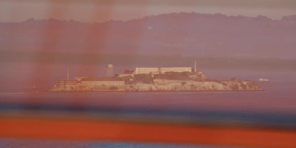 Boats approaching alcatraz island from the golden gate bridge
