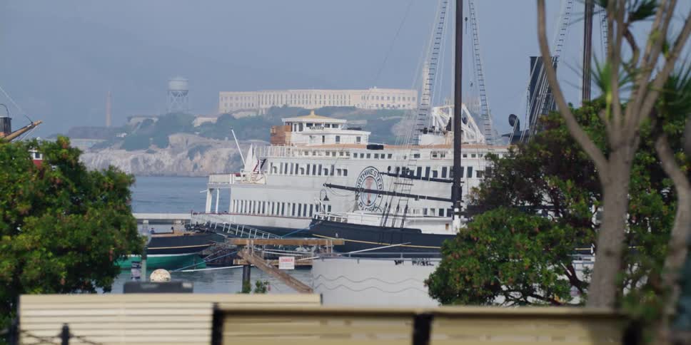 A ferry docked at the harbor with alcatraz island in sight