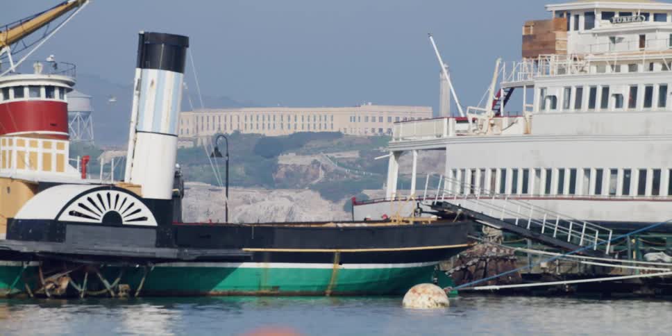 Abandoned steam boat and ferry in front of alcatraz island in san francisco
