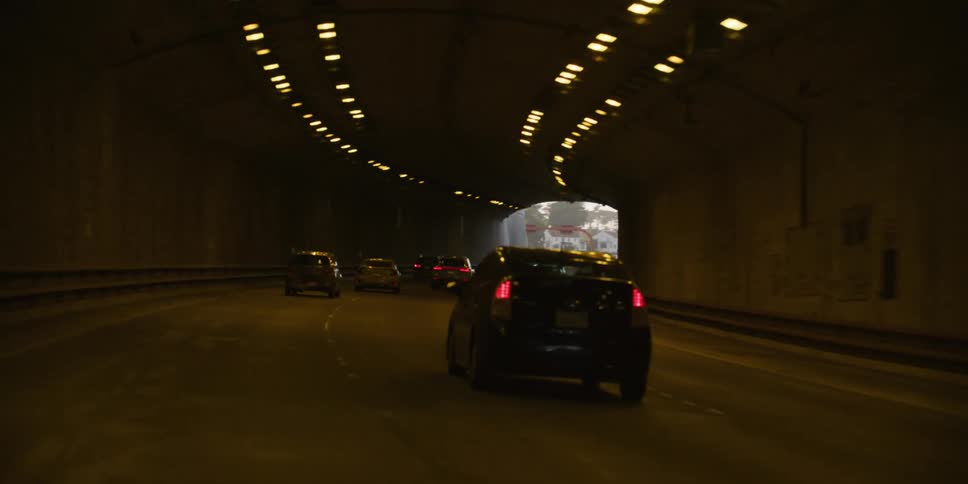 Cars driving in a highway and then entering a tunnel