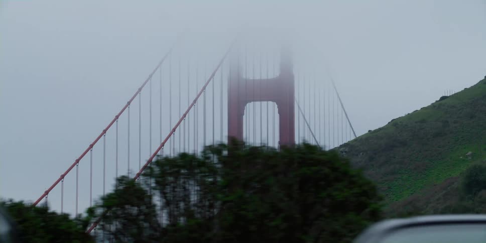 Cars are parked outdoors in spring next to a bridge