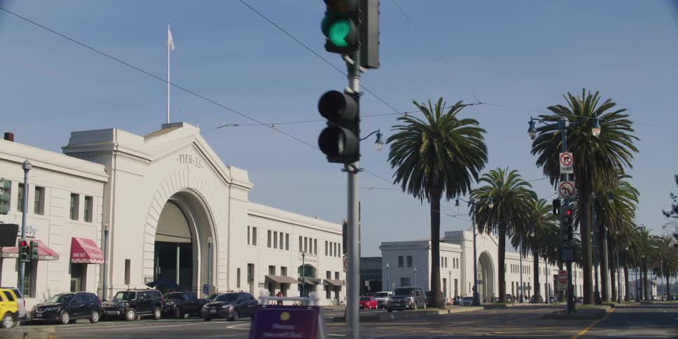 Traveling past pier 33 on a palm tree lined waterfront street