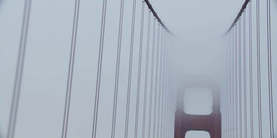 Cars driving across a bridge on a foggy day