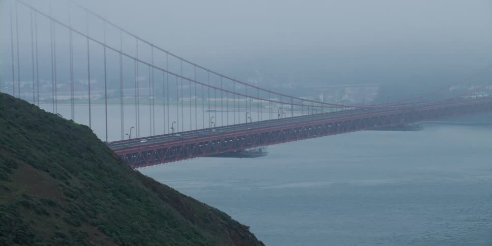 Vehicles travel over the large red bridge