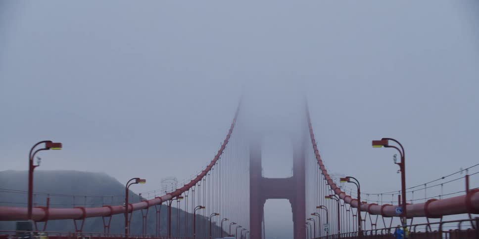 Traveling across a suspension bridge and looking up at the cables in the fog