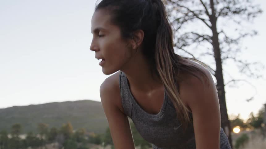 A woman stops jogging to catch her breath and gaze at her surroundings