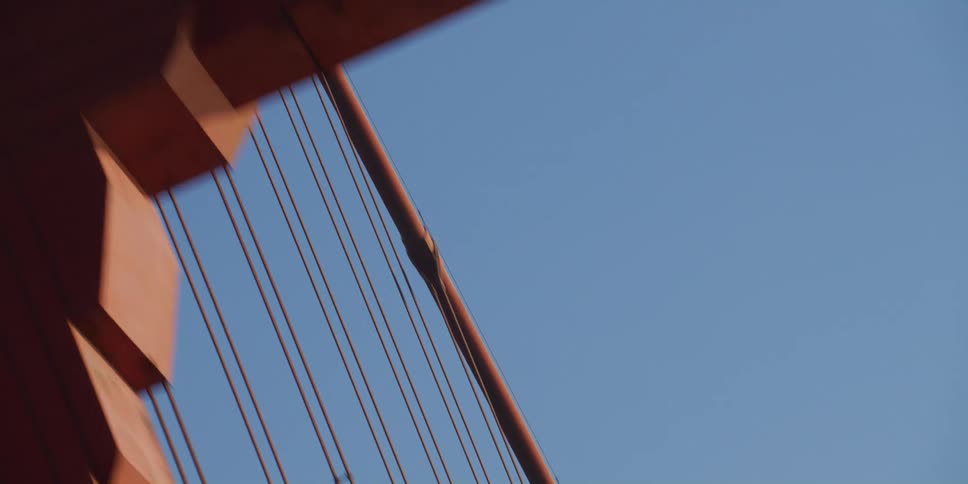 Twisting footage of the beams and cables of the golden gate bridge at morning