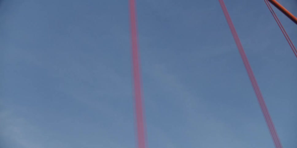 Twisting footage of the calbes and beams of the golden gate bridge at morning