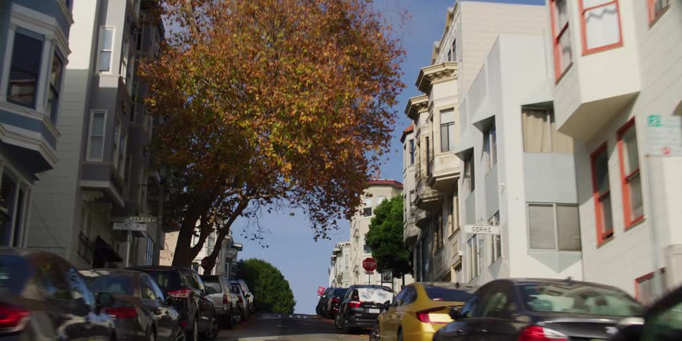 A man is walking up the street in the neighborhood