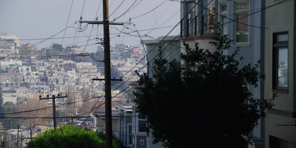Inner city neighborhood with multiple small buildings and a parked grey car