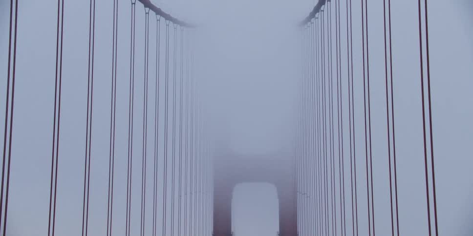 Dramatic zoom warp footage of the cables and tower in the golden gate bridge under the fog