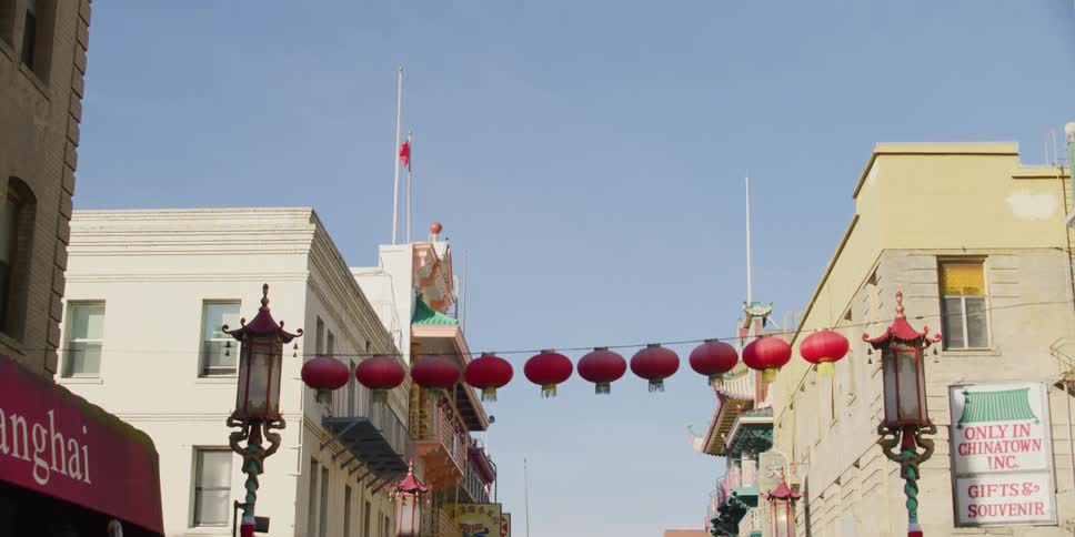 A street of a chinese neighborhood with chinese decoration and buildings and parked cars