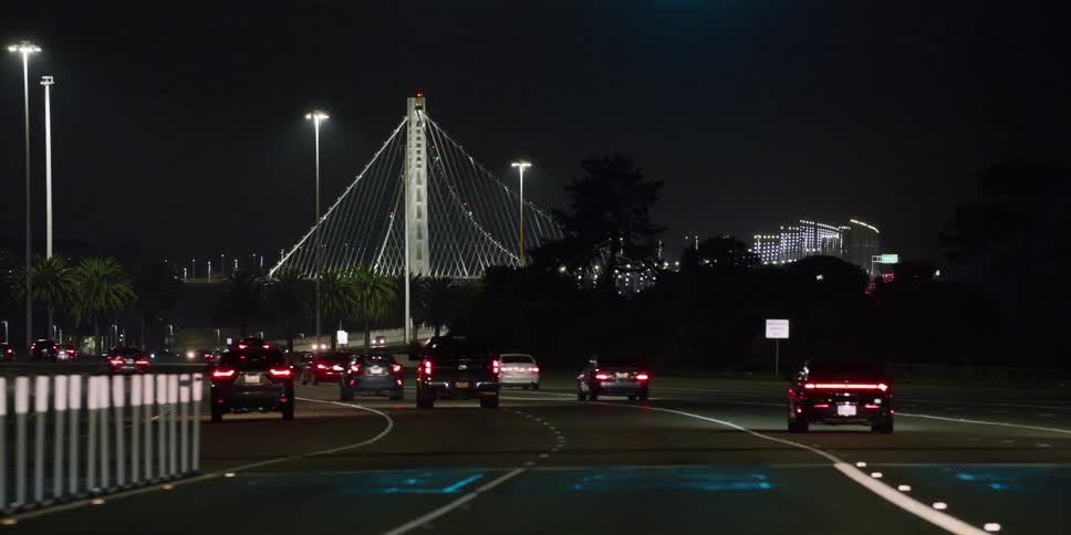 Cars are driving on an interstate at night