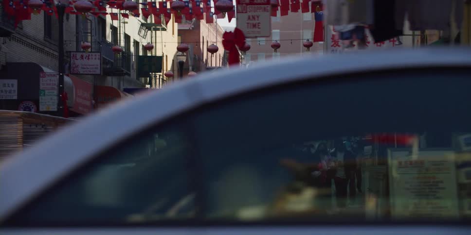 Cars parked and pedestrians walking on chinatown street in the city downtown at morning