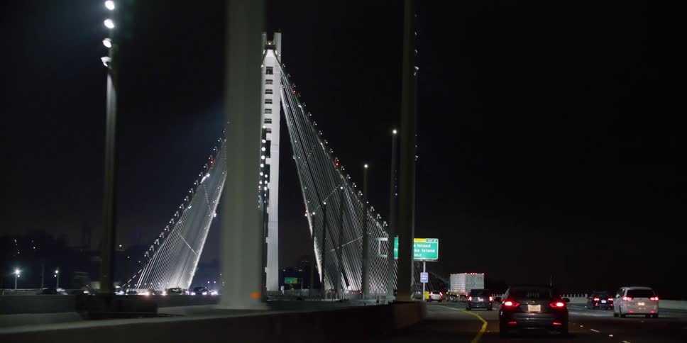 Vehicles driving across a bridge at night