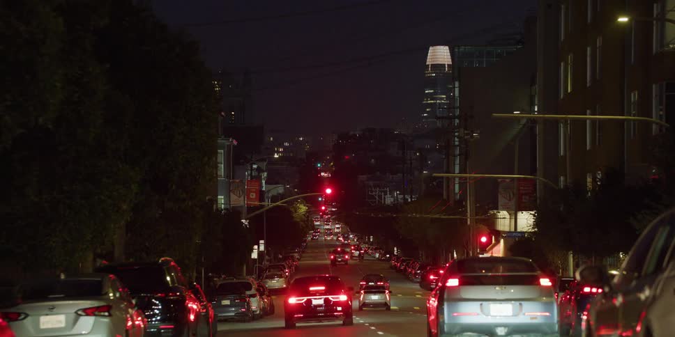 Vehicles drive on city highway in city street at night