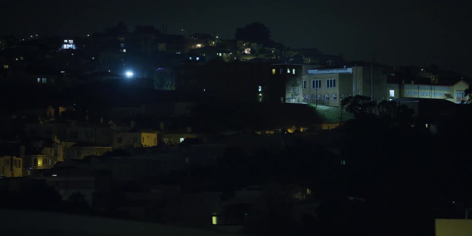 City streets with buildings seen from a moving car at night