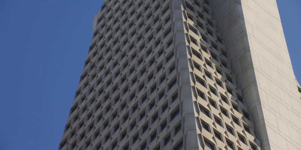 Looking up at a tall skyscraper with many windows