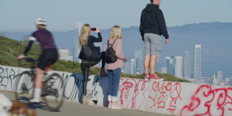 Tourists contemplating and taking pictures of the city skyline in the distance