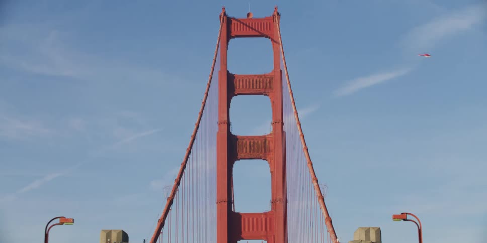 People stop by a tourism center for the golden gate bridge as traffic passes by