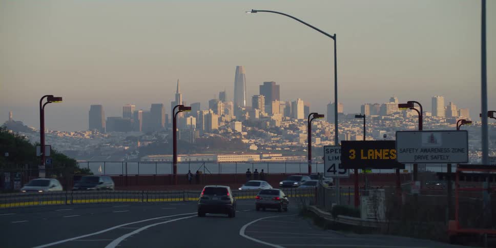Driving on the highway in front of the san francisco skyline at sunset