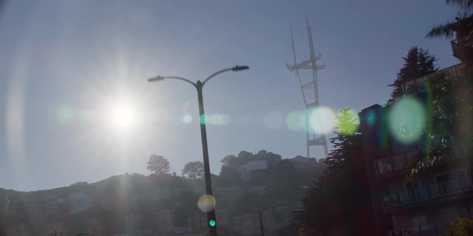 Homes sit along a hill near a transmission tower