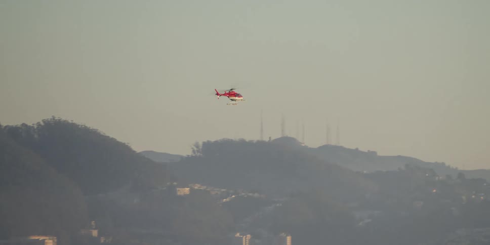 A helicopter is flying in the air at dusk
