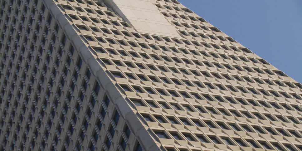 Looking up at a tall skyscraper with many windows