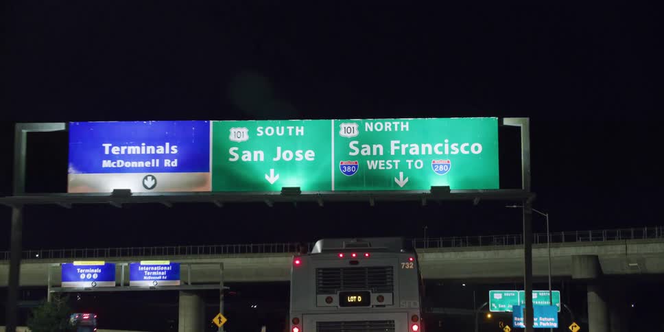A bus travels on a highway in the lane to go to san francisco