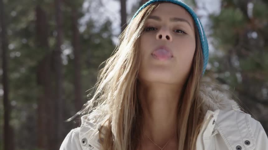 A woman smiling and sticking her tongue out at the camera