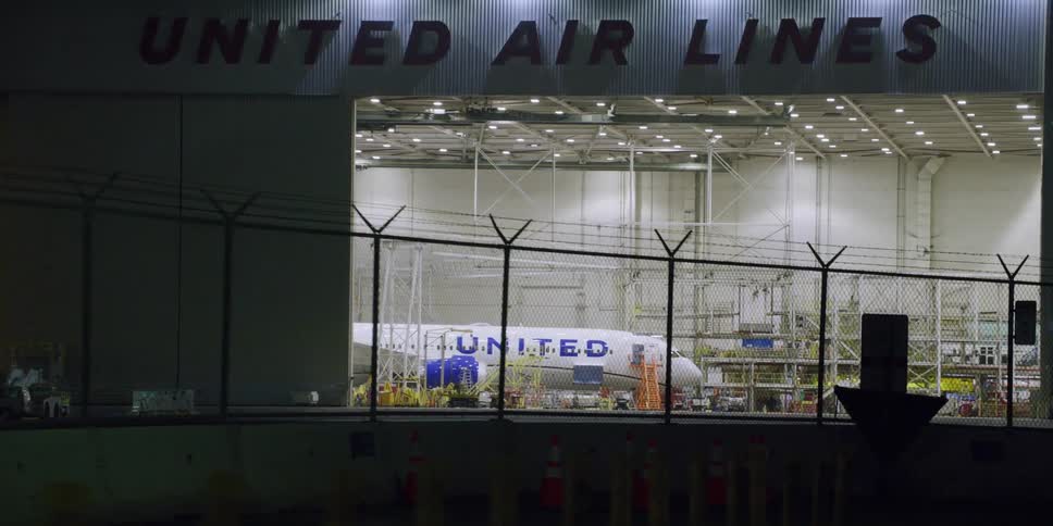 An airplane is parked at an airport at night