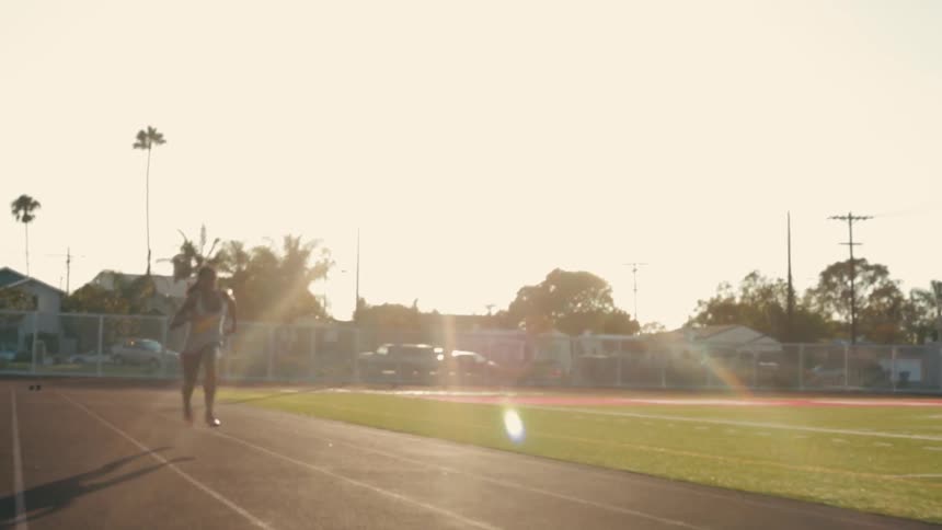 A female athlete runs down a lane on a track field